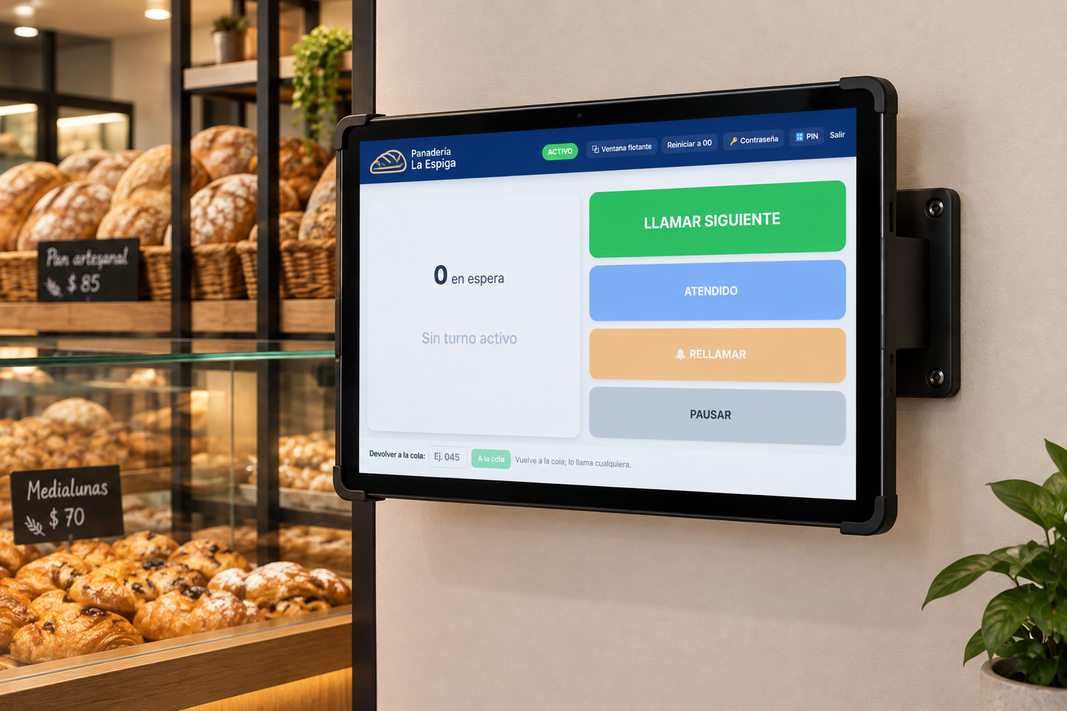Tablet del operador montada en la pared con soporte, junto al mostrador de una panadería